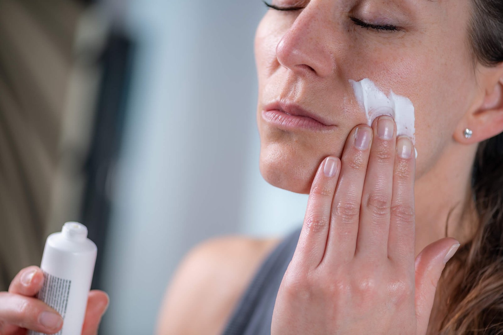 Dermatologist sunscreen guide — woman applying SPF to face